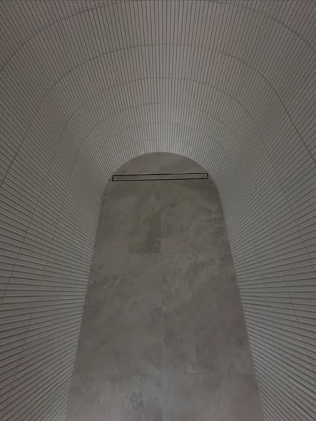 Curved vaulted shower detail with stone floor