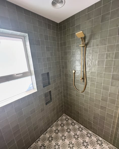 Green gloss tiled shower with patterned floor